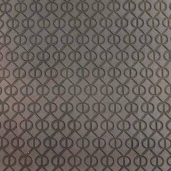 Gray leather rug with repeating circular indentations within a diamond grid pattern, featuring a tactile embossed texture.